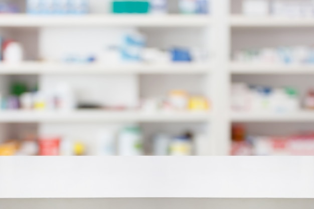 Pharmacy drugstore counter table with blur abstract backbround with medicine and healthcare product on shelves