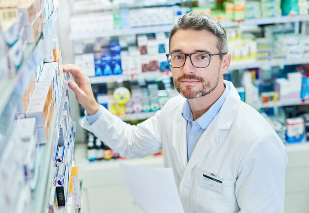 Pharmacy healthcare and portrait with man and shelf for pills advice and medicine inspection Medical insurance and antibiotic search with pharmacist for inventory drugstore and dispensary