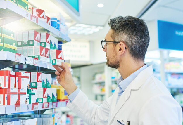 Pharmacy pills and search with man and shelf for medicine advice and healthcare inspection Medical insurance and antibiotic prescription with pharmacist for inventory drugstore and dispensary
