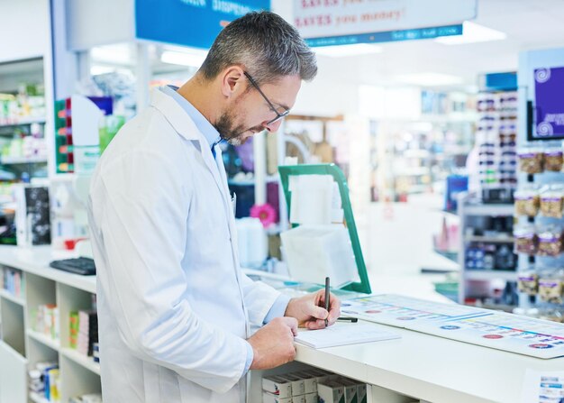 Pharmacy pills and writing with man and invoice for medicine advice and healthcare search Medical insurance and antibiotic prescription with pharmacist for inventory drugstore and dispensary