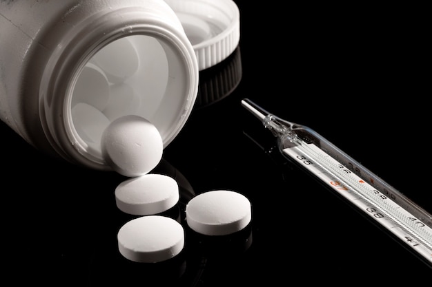 Pharmacy surface on a dark table. levitation pills. tablets on\
a dark surface which falling down. pills. medicine and healthy.\
close up of capsules. pills falling on black surface