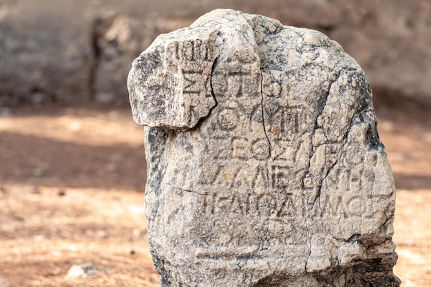 Phaselis, Turkey - November 08, 2021: half-erased antique Greek or Roman inscription on a stone among the ruins of ancient city