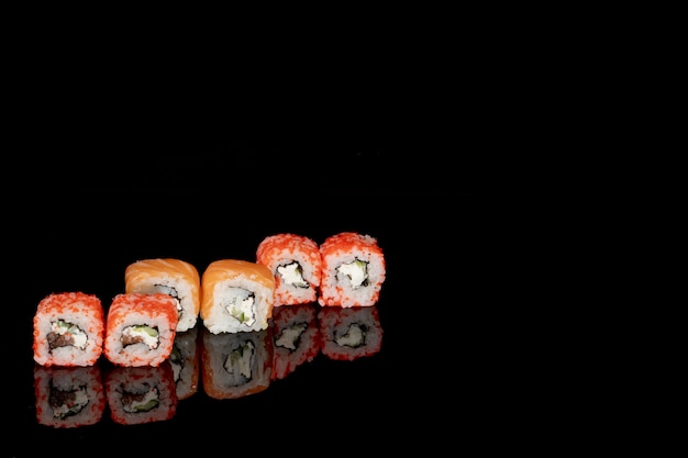 Philadelphia roll met zalm, kaas en komkommer op zwart