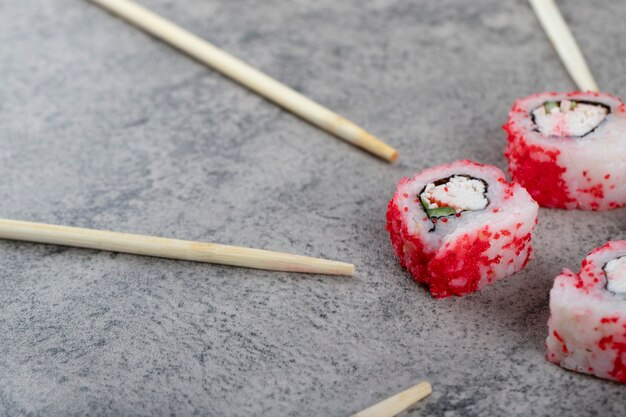 Philadelphia roll with fresh salmon, cucumber, cream cheese and chopsticks . 