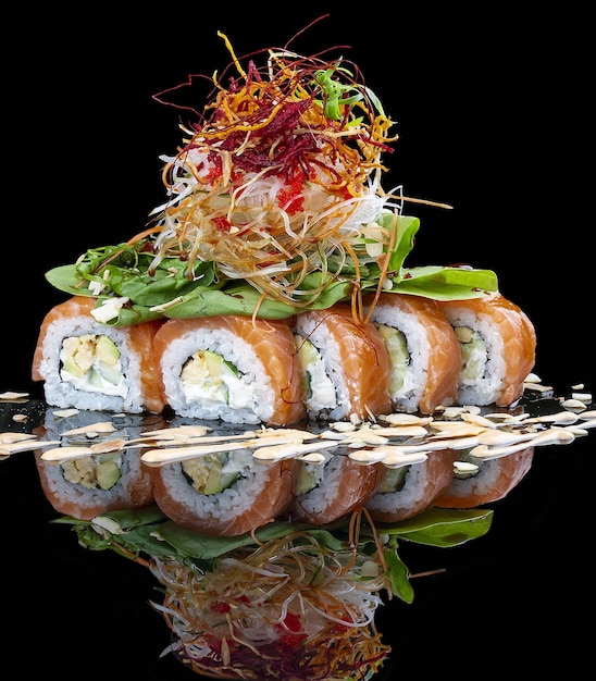 Philadelphia roll with salmon and lettuce on glossy black background
