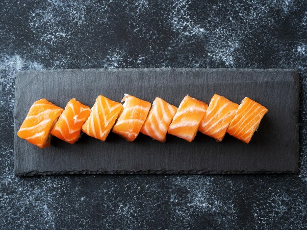 Philadelphia rolls liggend op een leistenen serveerplank Sushi set met zalm avocado roomkaas