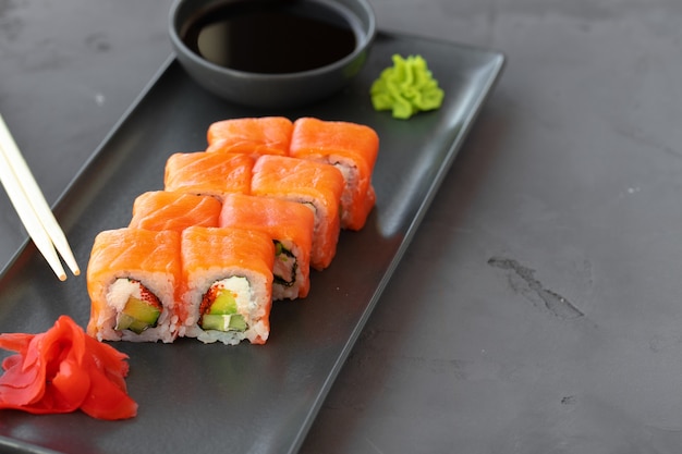 Philadelphia sushi roll served on black ceramic plate