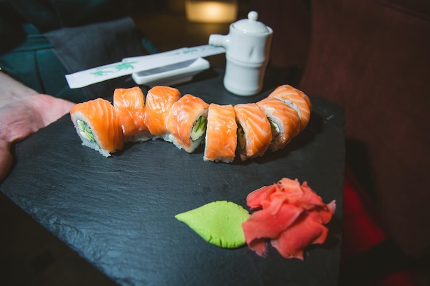 Foto rotolo di sushi philadelphia con salmone, cetriolo, avocado, crema di formaggio. menù sushi. cibo giapponese.