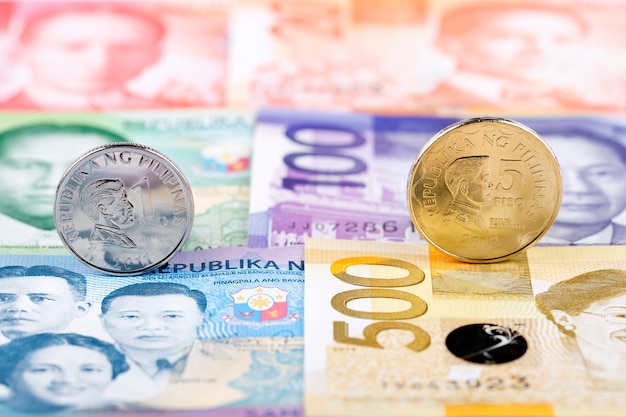 Philippine peso coins on the background of banknotes 