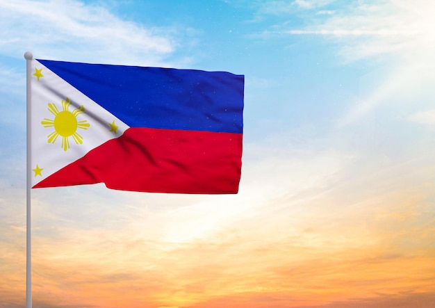 Photo philippines flag extended on a flagpole and in the background a beautiful sky with a sunset