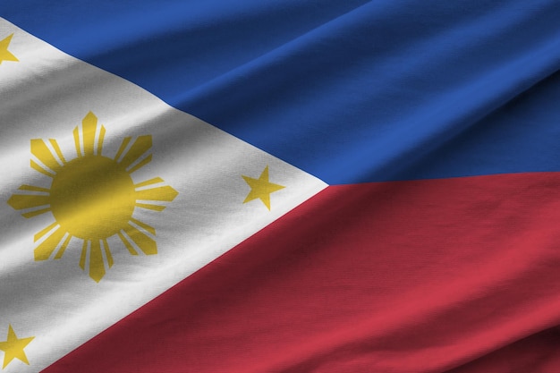 Philippines flag with big folds waving close up under the studio light indoors The official symbols and colors in banner