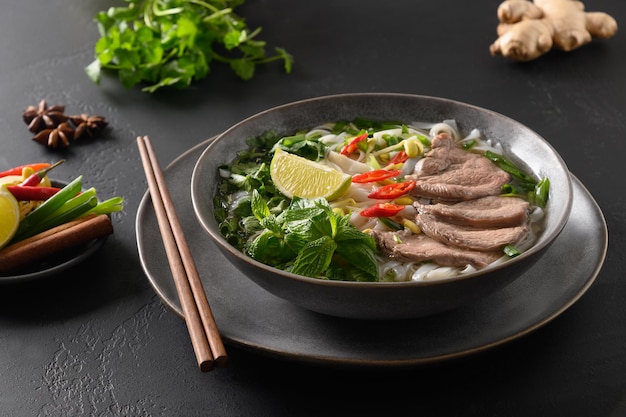 검은 배경 베트남 요리에 그릇에 쇠고기를 넣은 포보 수프