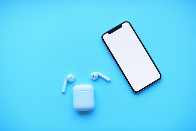 phone and air pods on blue background