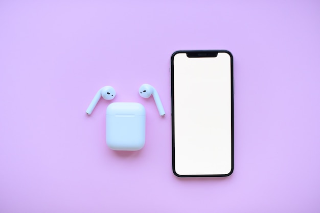 phone and air pods on pink background