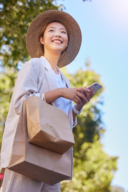 Телефонная азиатская женщина и сумка для покупок со счастливой улыбкой и технологиями с 5g web outdoor