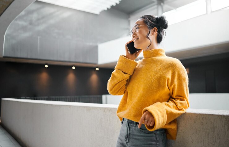 Photo 廊下に立って話しているアジアの女性との電話通信とモックアップ モバイルネットワーキングと屋内のスマートフォンで話している魅力的な若い女性との会話
