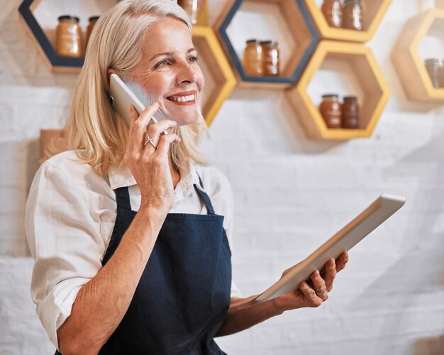 Foto telefonata tablet e miele con una donna al dettaglio che registra un ordine online tramite comunicazione mobile e-commerce aziendale e vendite di nettare con una dipendente che parla mentre lavora nel suo negozio