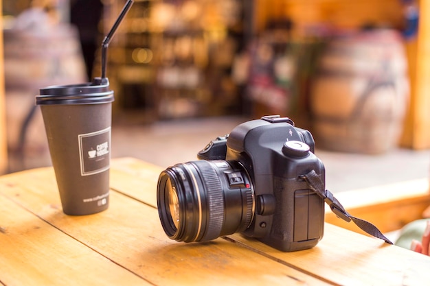 phone and camera on a wooden table in a cafe