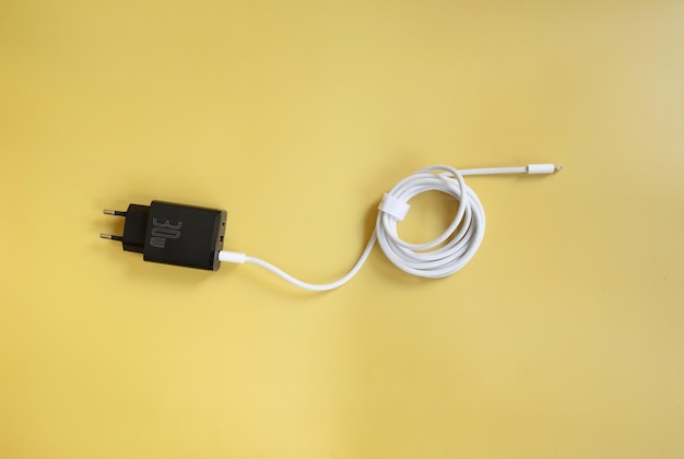 Phone charger and USB cable on yellow background