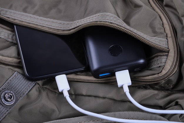 Phone charging,powerbank charges smartphone,cellphone with energy bank. Depth of field on Power bank in the backpack bag