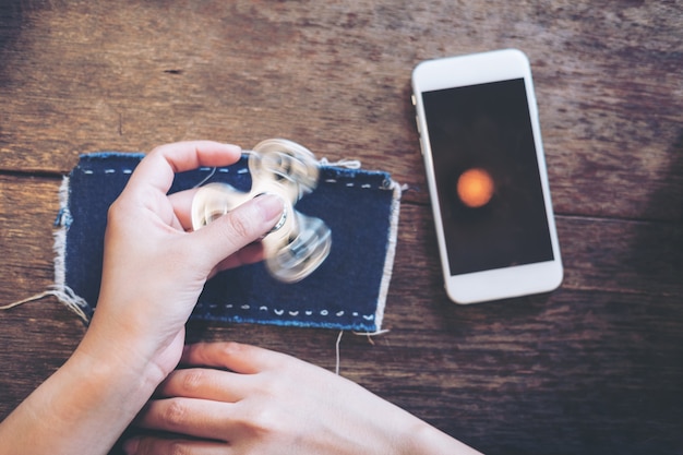 phone and hand playing fidget spinner