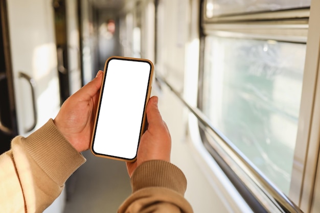 Phone in hands with an isolated screen on the background of the train cabin