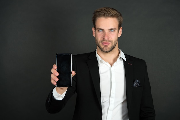Phone keeps him organized. Businessman show mobile phone. Handsome man with cell phone. Phone for personal and professional use. 3G and 4G. Mobile lifestyle. Smartphone for keeping in touch.