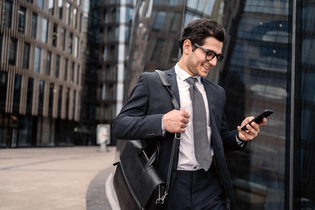 Phone message a manager with glasses goes to work in the office in a business suit smiles