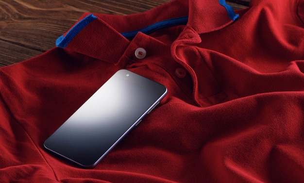 Phone mockup with blank screen on red t-shirt fabric. smartphone in everyday life.