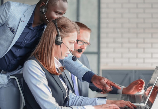 Phone operator working at call centre office helping hiss colleague