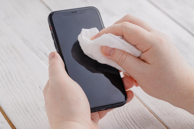 Photo phone screen disinfecting wipe cleaning removing germs with antibacterial wipes for corona virus covid-19