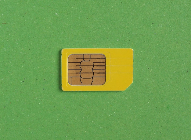 Photo phone sim card over green with copy space