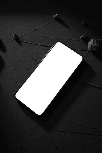 Foto telefoni la vista superiore con lo schermo bianco su calcestruzzo, tavolo di pietra. luce intensa e ombre