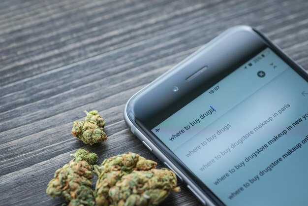 Phone and weed on a rustic wooden board