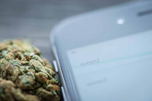 Phone and weed on a rustic wooden board