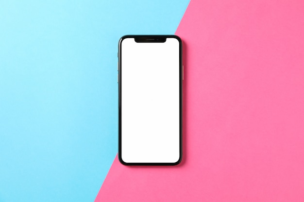 Phone with empty screen on two tone background, top view