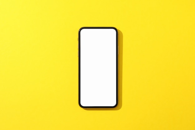 Phone with empty screen on yellow surface