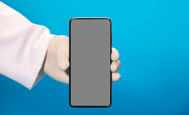 Phone with gray screen mockup in the hands of a doctor with sanitary gloves