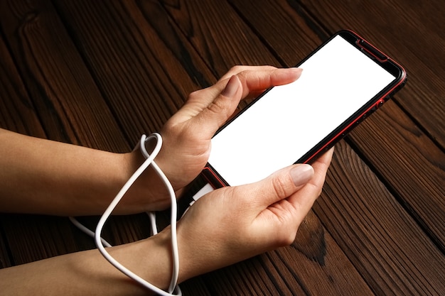 A phone with hands addiction on a wooden surface