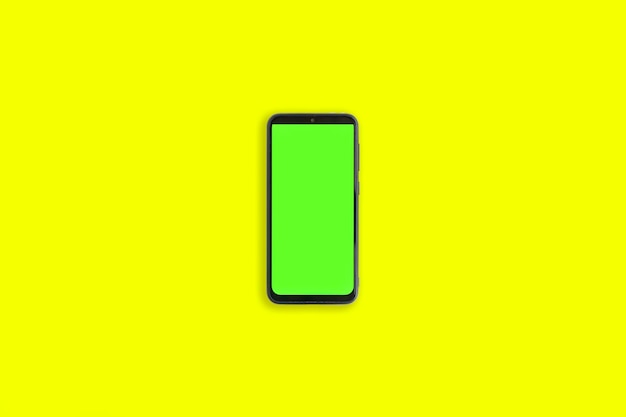 Phone with vertical green screen with chroma key isolated yellow background Mock Up Display Smartphone gadget for advertising Top above view Mobile phone with empty blank screen Layout template