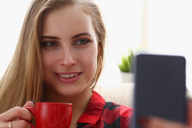 phonWoman drinking coffe and look at smartphone