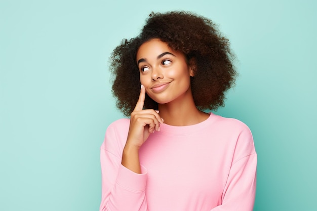 Photo of admiring young pretty African American girl brown hair wear pink crop top touch finger chin dreams look novelty isolated on cyan color background