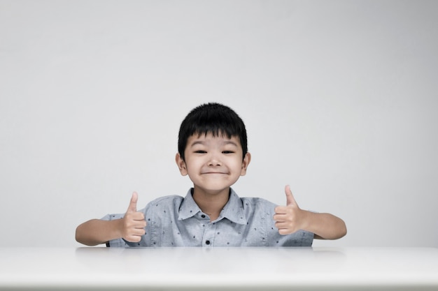 Photo of the adorable young happy boy looking at the camera, on the white background.