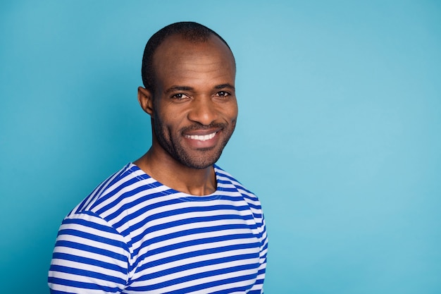 photo of afro american guy look copyspace beaming smiling isolated over blue color background