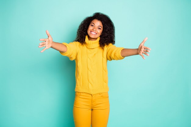 Foto foto di una fantastica signora di pelle scura con le braccia aperte in attesa del migliore amico che viene per abbracciare indossare pantaloni pullover lavorati a maglia gialli isolati a parete color verde acqua