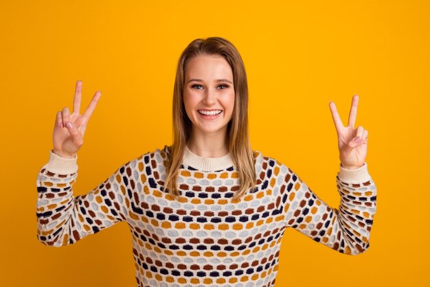 Photo of amazing lady showing vsign symbols saying hello isolated yellow color background