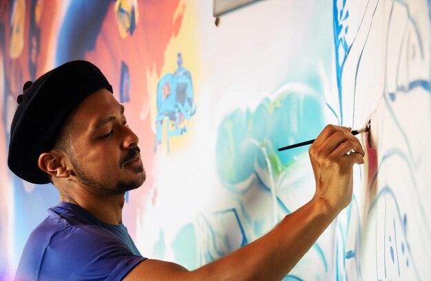 photo of an artist is drawing a mural on the wall