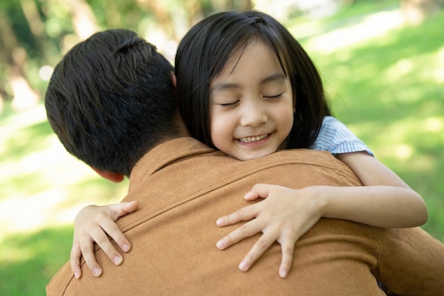 photo of asian father and daughter at park
