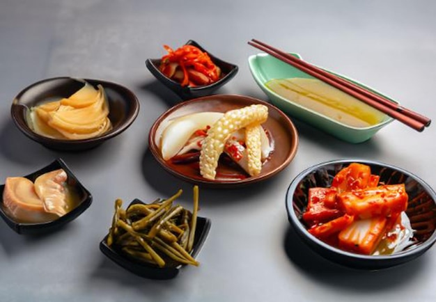 Photo assorted korean pickled food and chopsticks on gray background