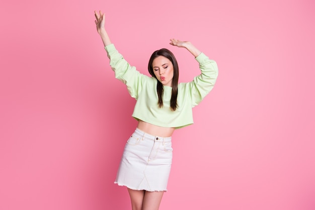 Photo of attractive adorable lady raise arms dance disco hit party slim figure dancer wear casual green crop pullover naked belly jeans short skirt isolated pink pastel color background